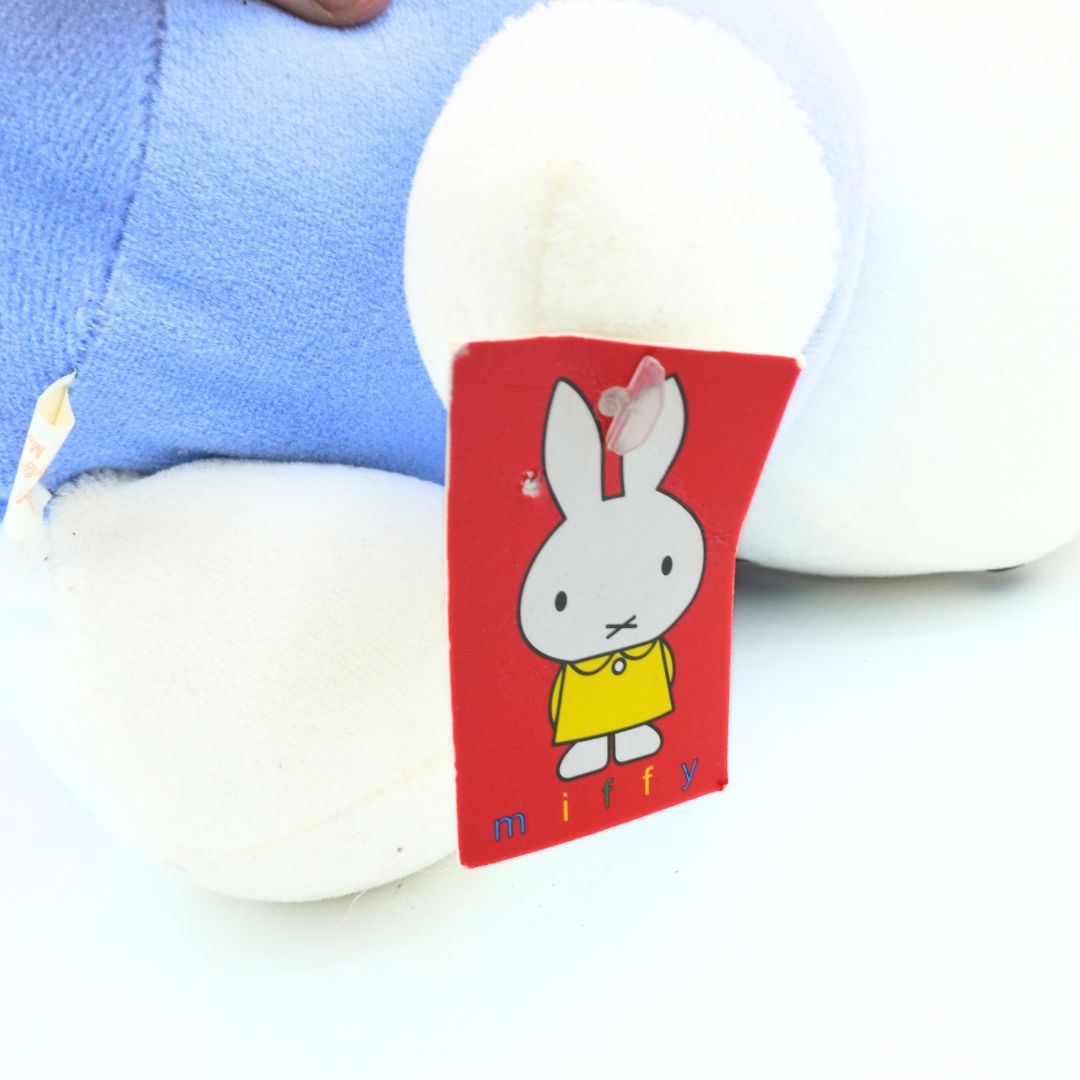 Plush toy with a red tag featuring a cartoon rabbit character on a white background
