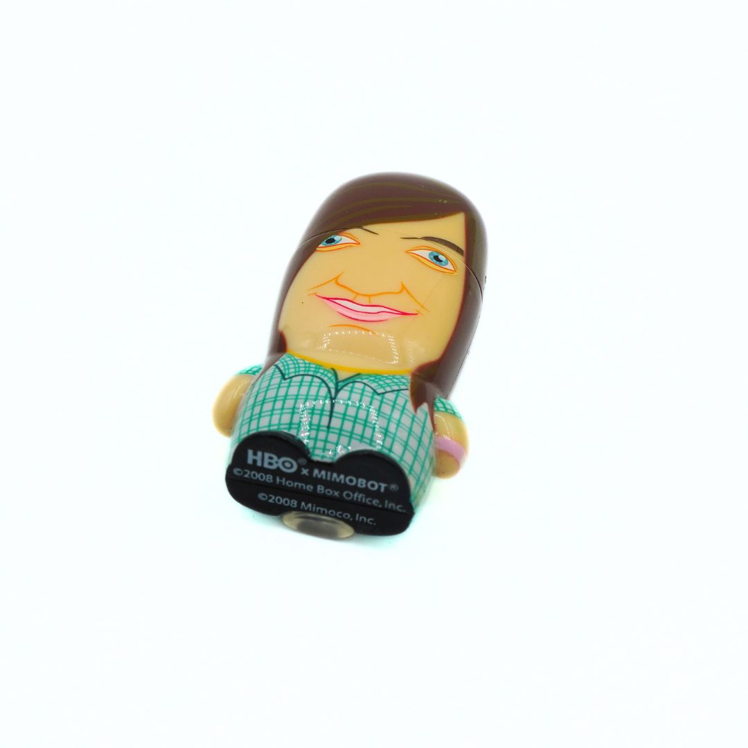 A novelty collectible figurine of the HBO 'Summer Heights High' character Ja'mie, featuring a stylized cartoon face with brown hair, blue eyes, and a green checkered shirt, mounted on a black display base with HBO branding.