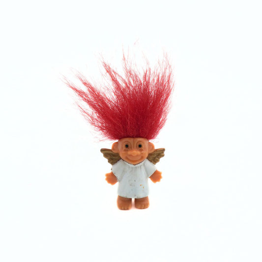 Toy figure with red hair and wings on a white background
