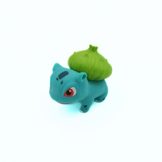 Blue creature plush toy with a green ball on its back against a white background