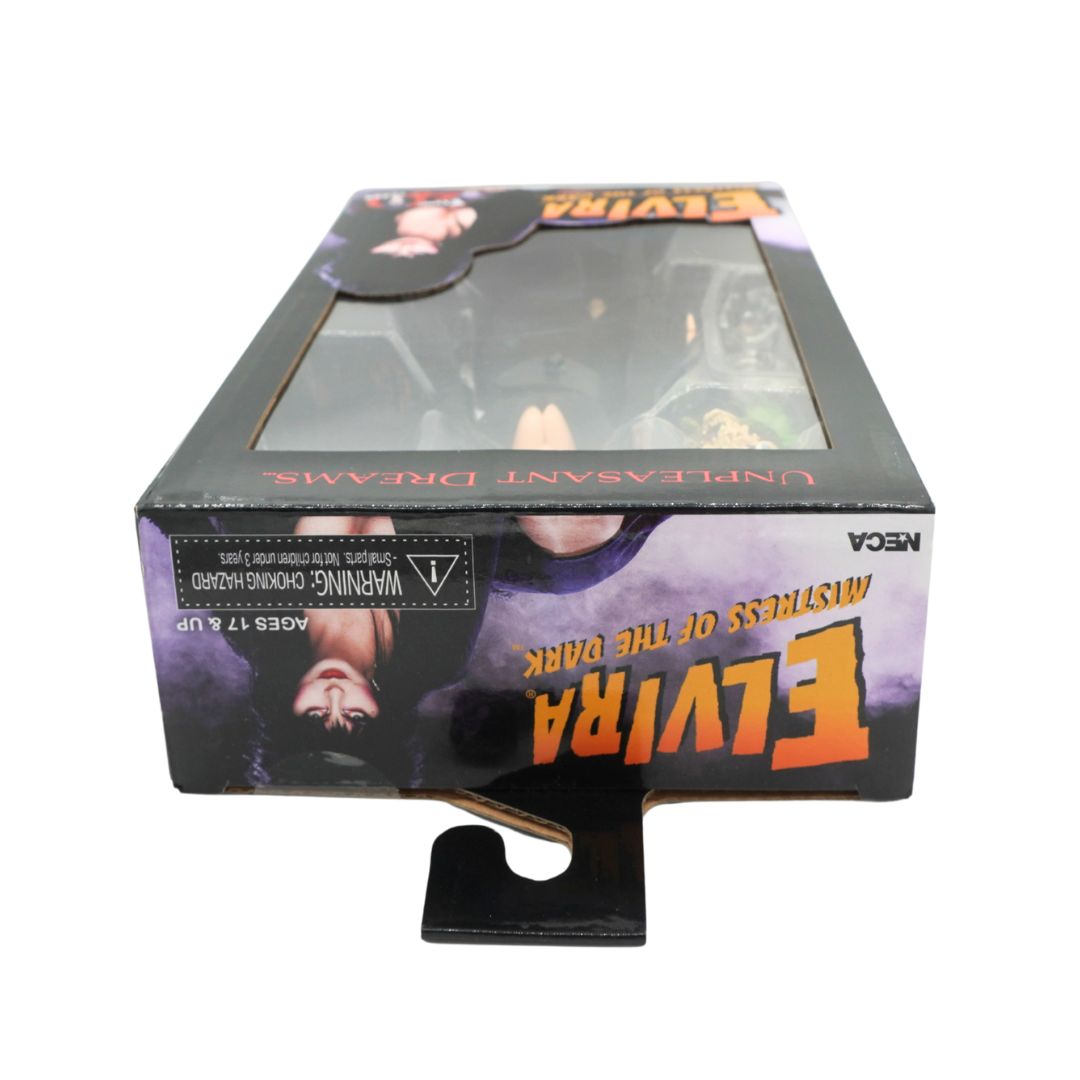 NECA Elvira 'Mistress of the Dark' Mystery of the Black action figure in its original window box packaging, featuring a black and purple horror-themed design with orange lettering.