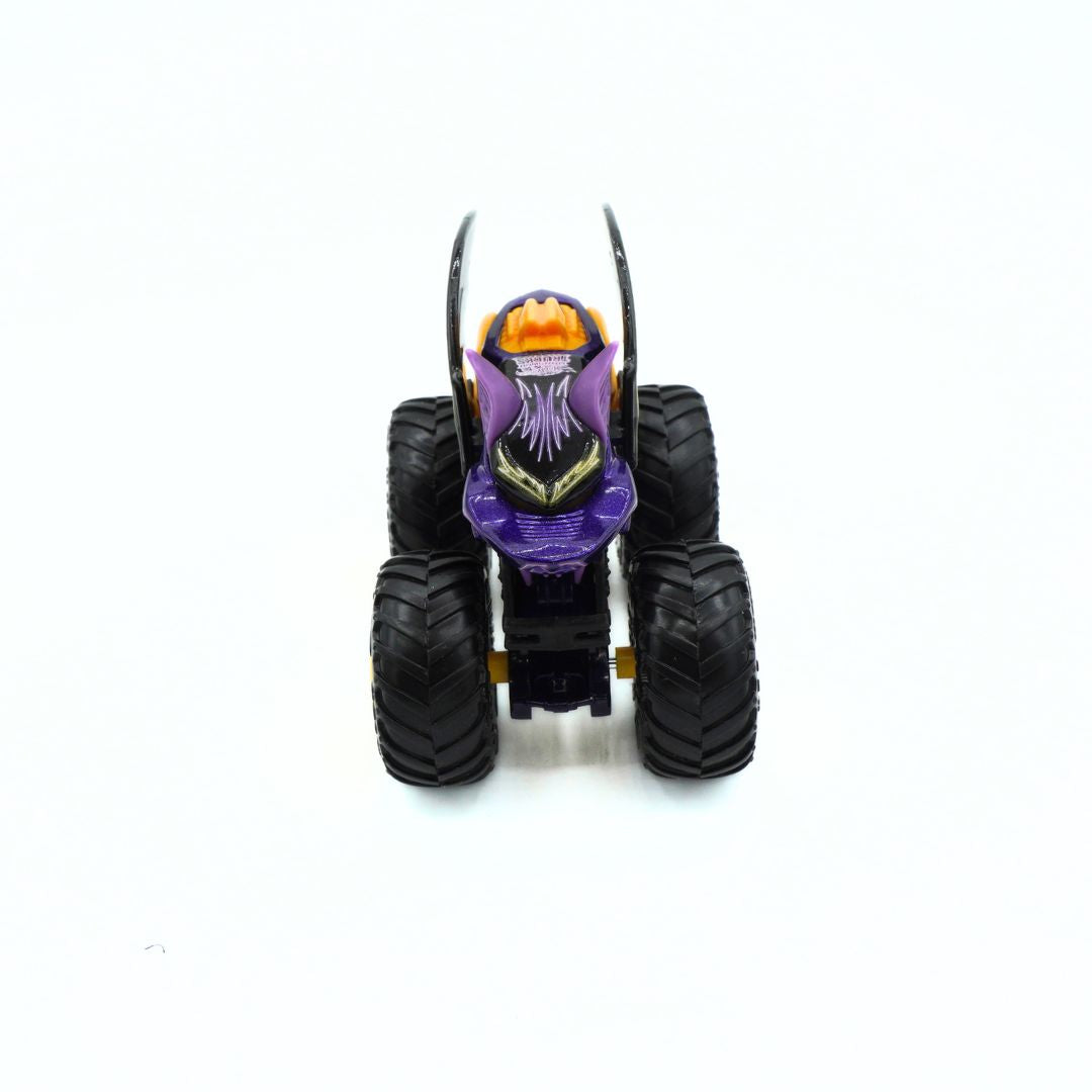 A small monster truck toy with large black tires, a purple body, and an orange hood, photographed against a plain white background.