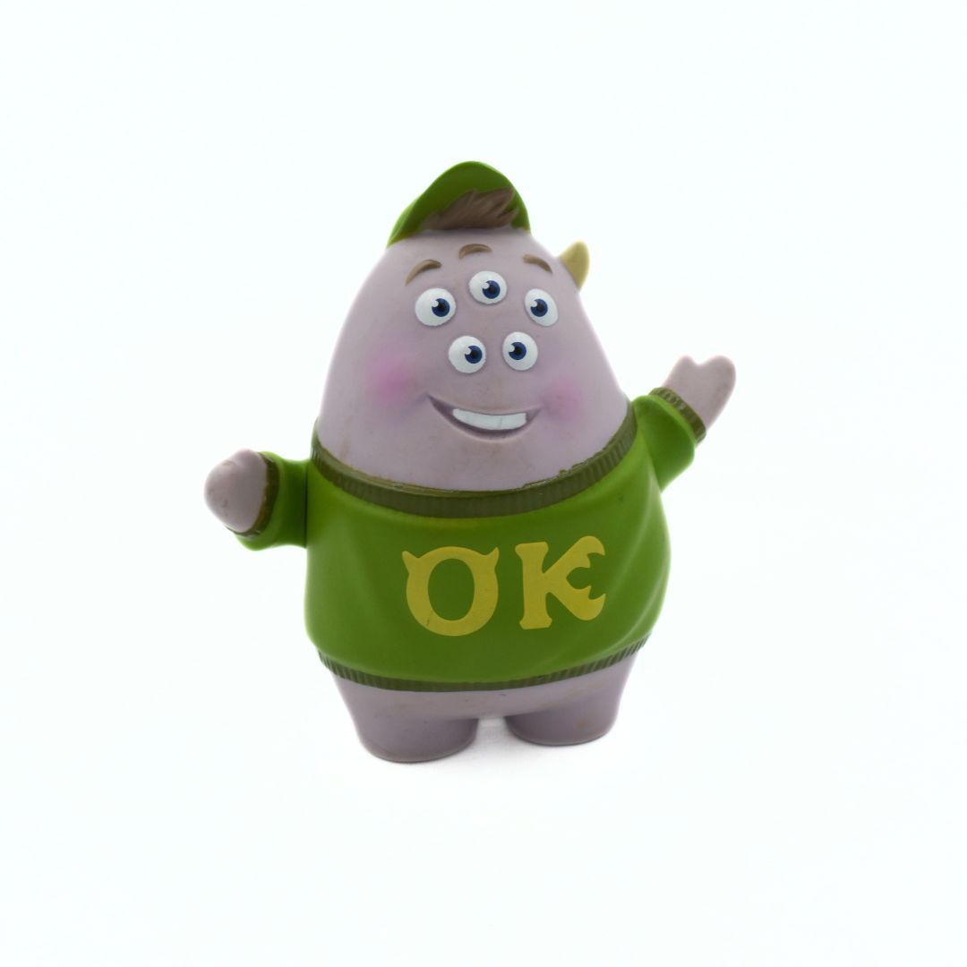 Toy figure of a character wearing a green shirt with 'OK' on it against a white background