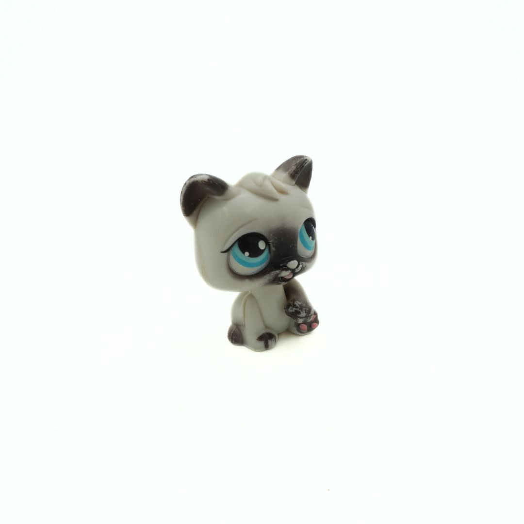 Small figurine of a cat with blue eyes on a white background
