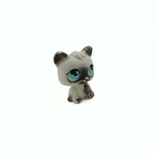 Small figurine of a cat with blue eyes on a white background