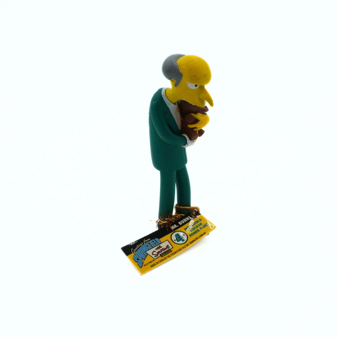 Simpsons figurine of a character holding a baby on a white background