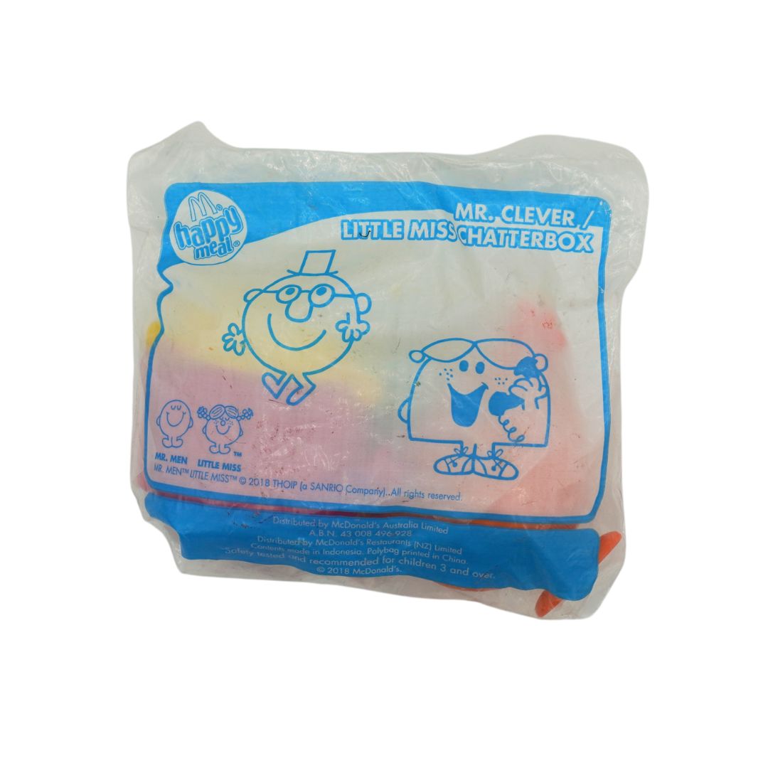 A McDonald's Happy Meal toy, specifically the 'Little Miss Chatterbox' featuring Mr. Clever and Little Miss, sealed in its original clear plastic packaging with a blue and pink printed label.