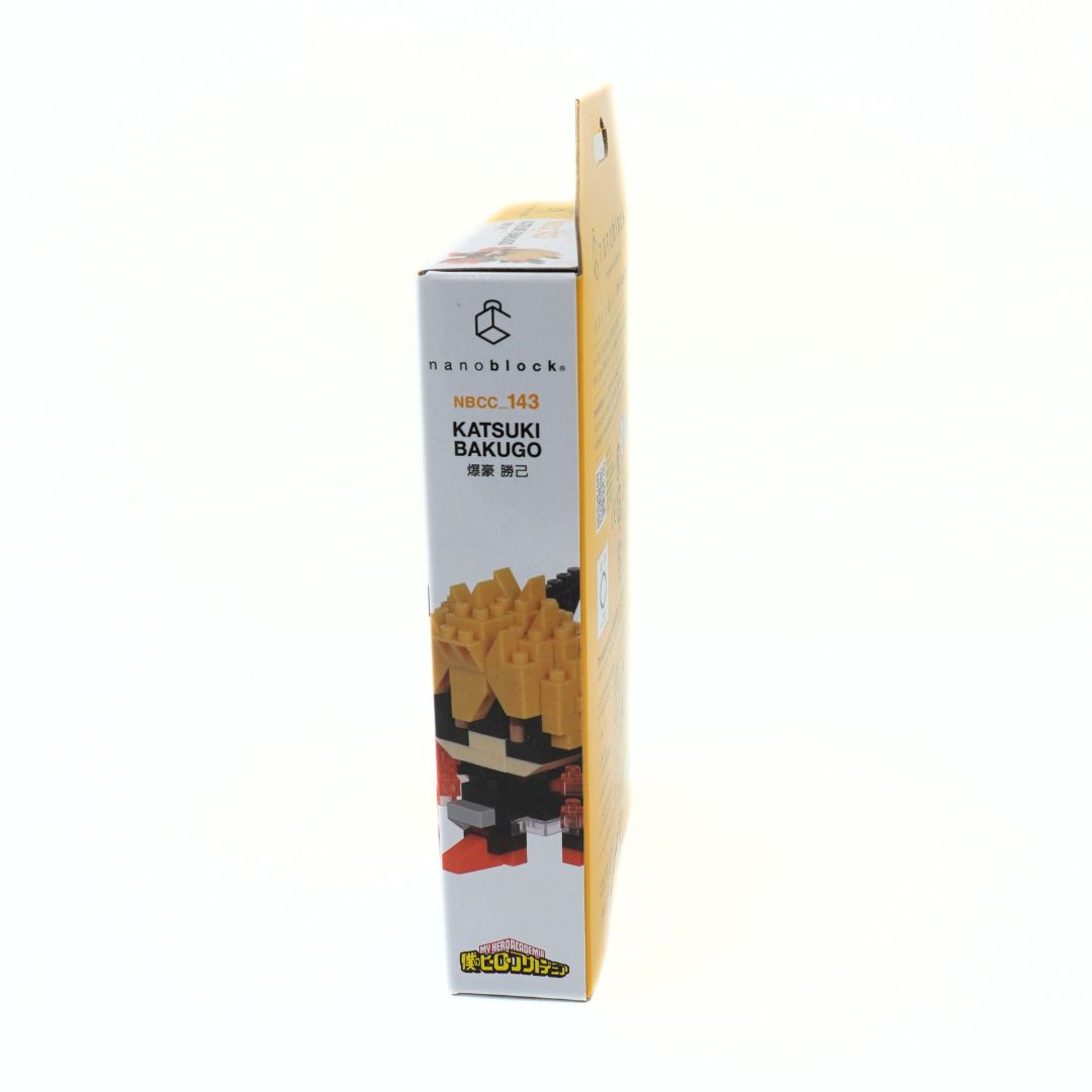 A boxed building block set shown upright on a plain white background. The package is mostly white with a yellow side panel and printed text reading 'nanoblocks' and 'KATSUKI BAKUGO,' plus a small illustration of assembled blocks.