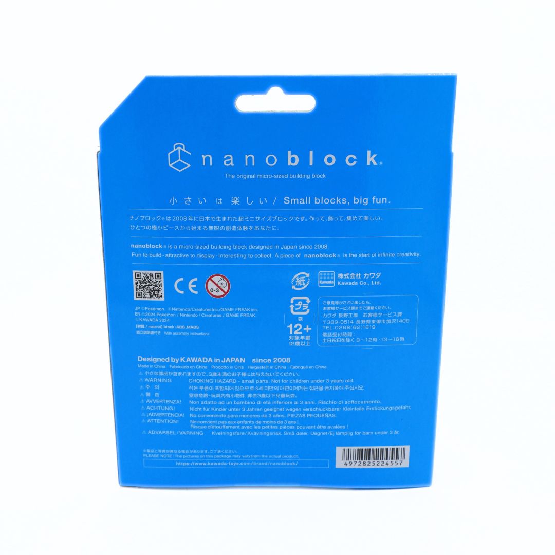 The back of a blue Nanoblock toy packaging card, featuring product information, safety icons, and a barcode on a white background.