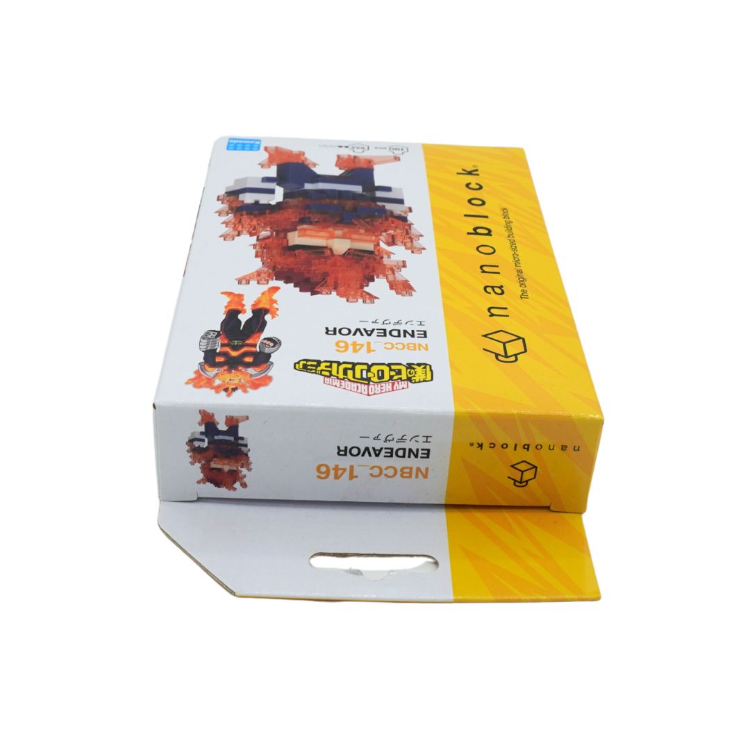 A boxed toy product on a plain white background. The packaging is primarily white with a large yellow side panel and printed graphics of a red-and-black monster-like figure.