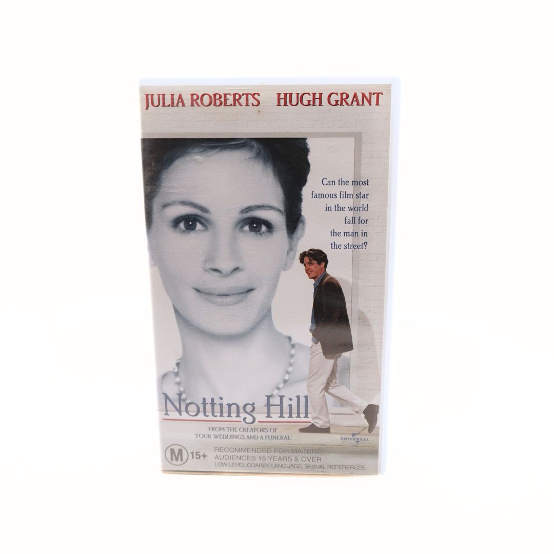 Front photo of the cover of the Notting Hill VHS featuring a poster of Julia Roberts with Hugh Grant walking in front of it