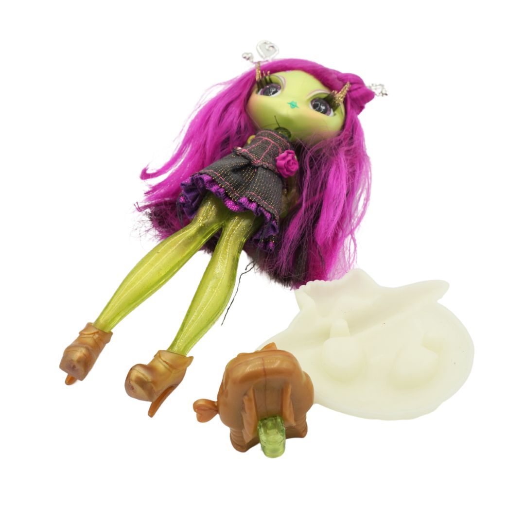 A Novi Star doll with green legs and purple hair, wearing a dark denim dress and standing on a cream coloured stand