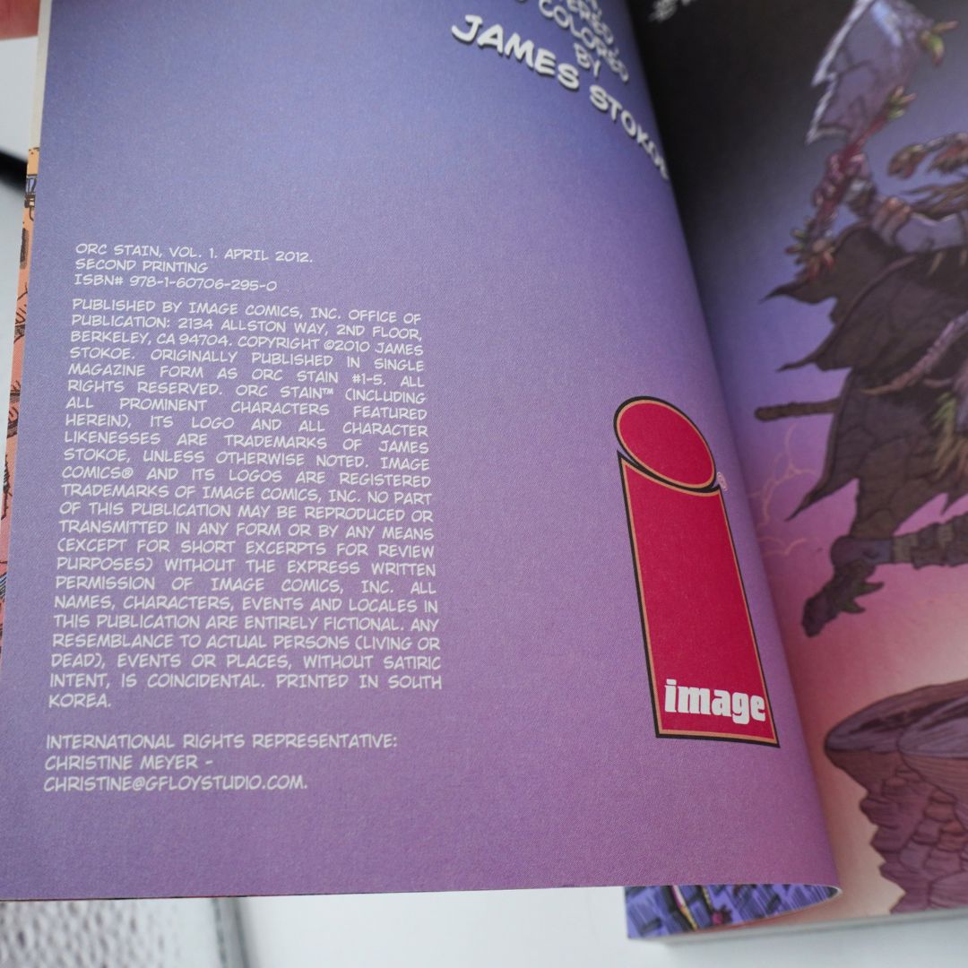An open printed comic book or book page showing purple interior covers with white copyright text, the Image logo, and fantasy artwork on the right page.