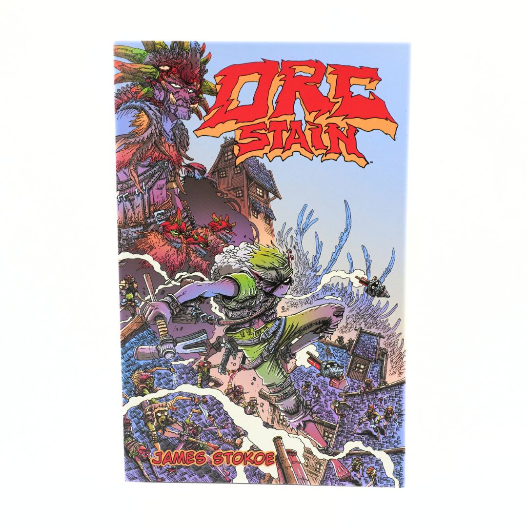 The front cover of the comic book 'Orc Stain' by James Stokos, featuring a highly detailed, colorful fantasy illustration of a warrior fighting a giant creature on a white background.