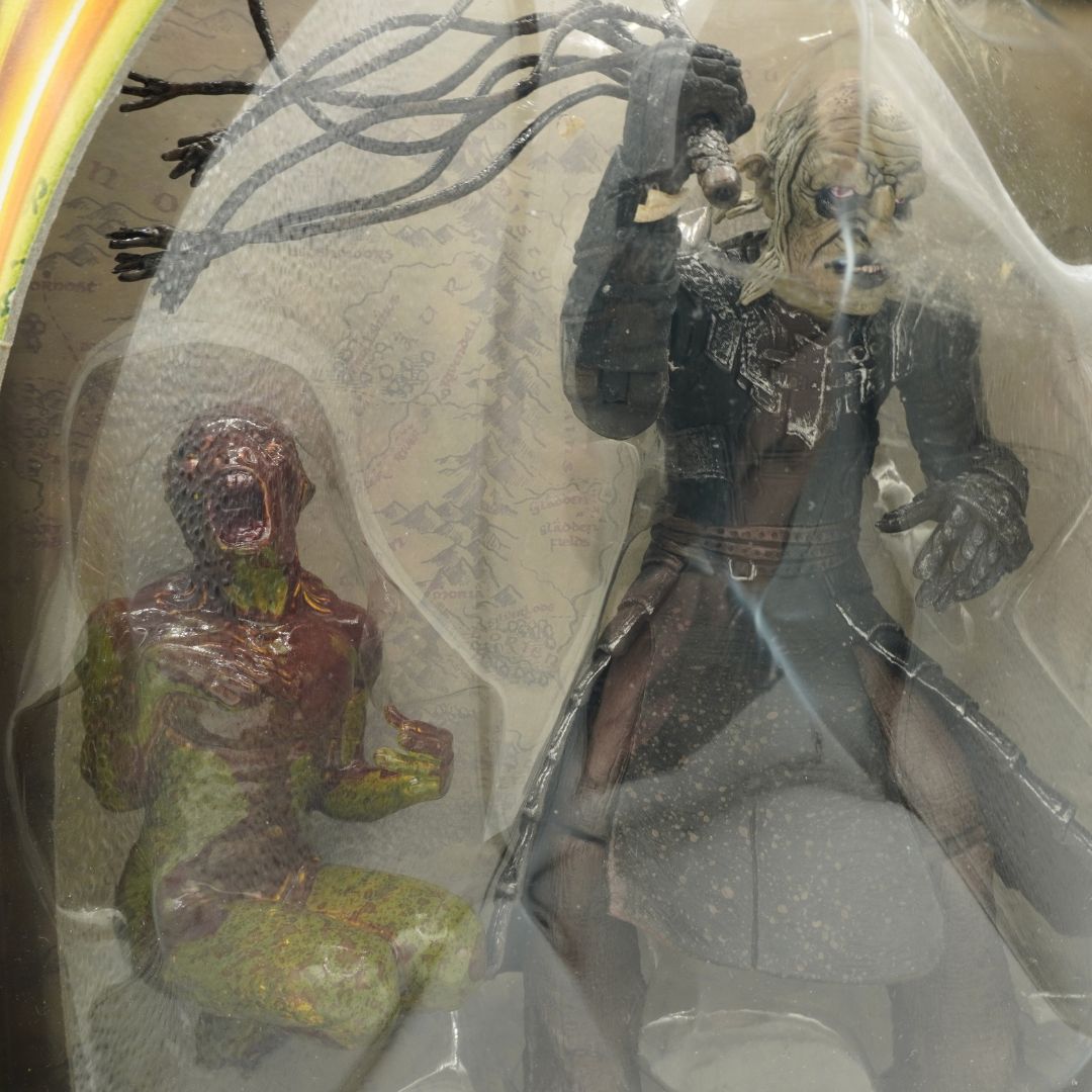 Two action figures in a clear plastic bag, one green and one with metallic details.
