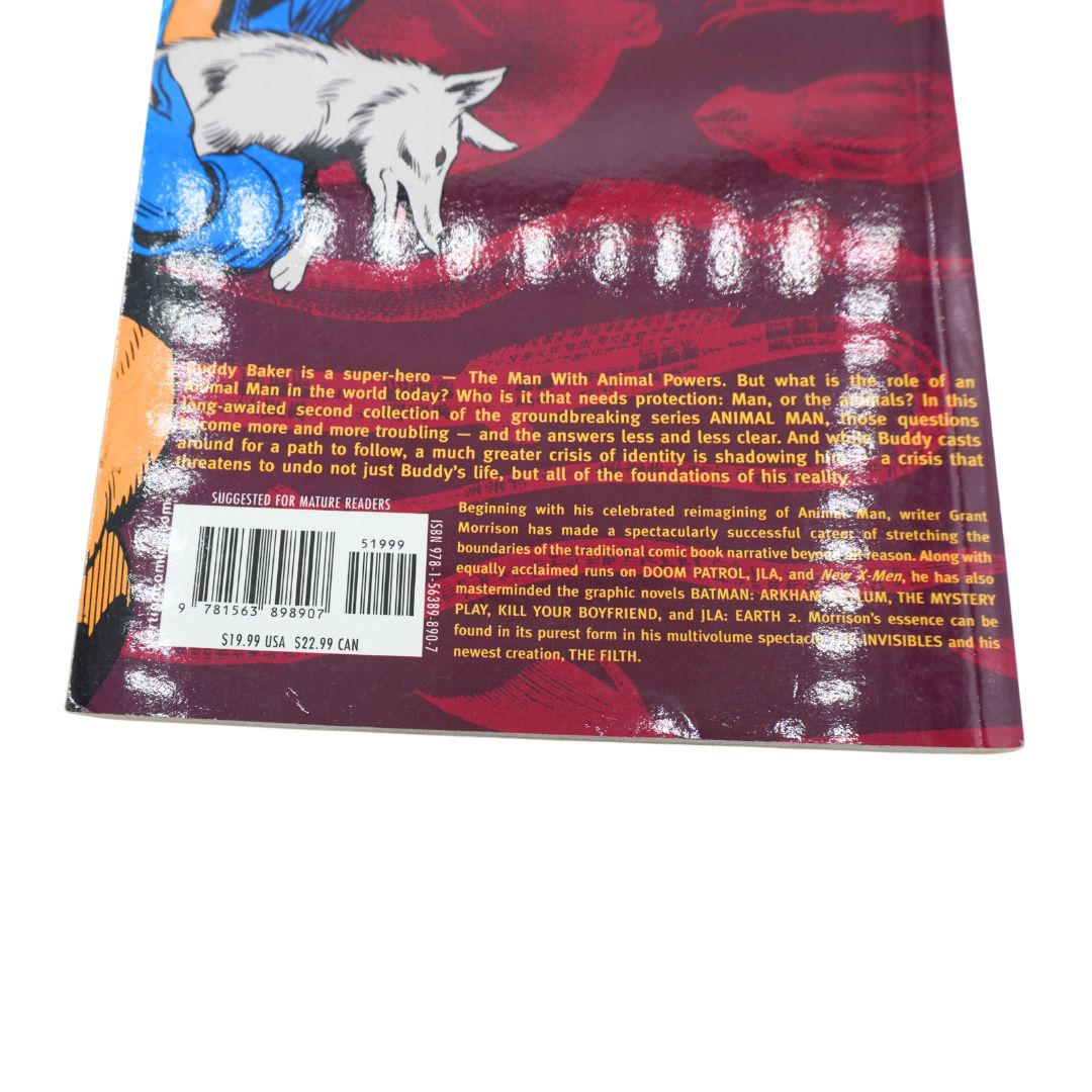 The back cover of a comic book or graphic novel, featuring a colorful illustration of a white dog on a blue and red background, with a barcode and extensive text on the lower portion.
