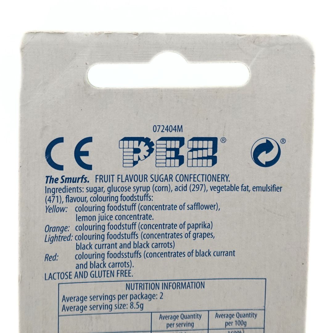 Closeup of the back of a Papa Smurf Pez Dispenser ingredient list, seen on the cardboard packaging