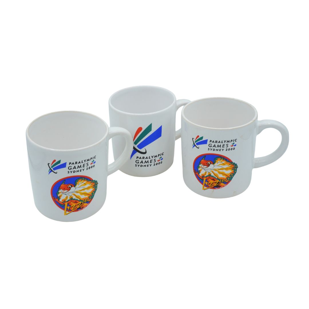 Three mugs with Paralympic Games Sydney 2000 logos on a white background