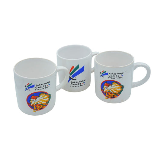 Three mugs with Paralympic Games Sydney 2000 logos on a white background