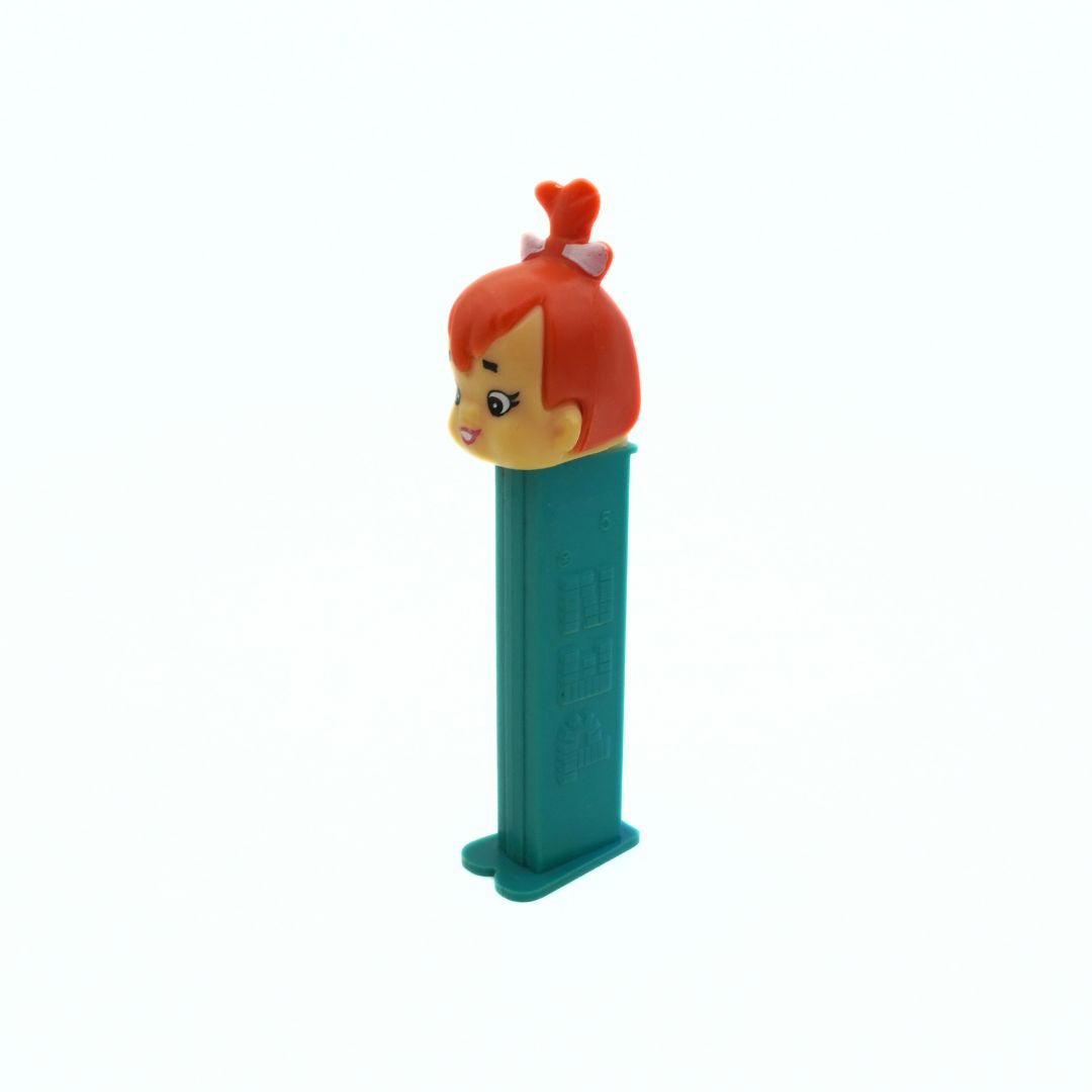 A vintage Pez dispenser of Pebbles from the Flinstones, with a green body