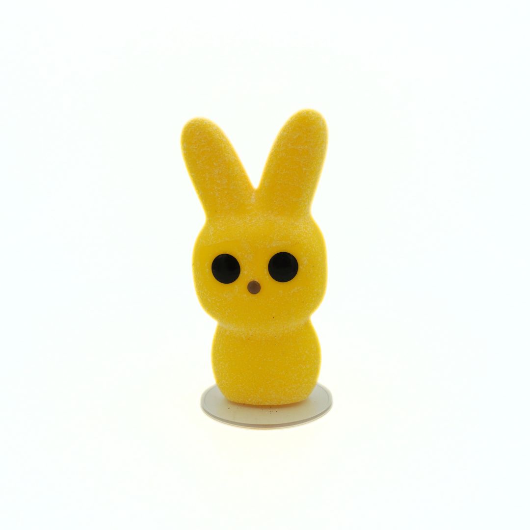 Yellow plush toy with rabbit ears on a white background