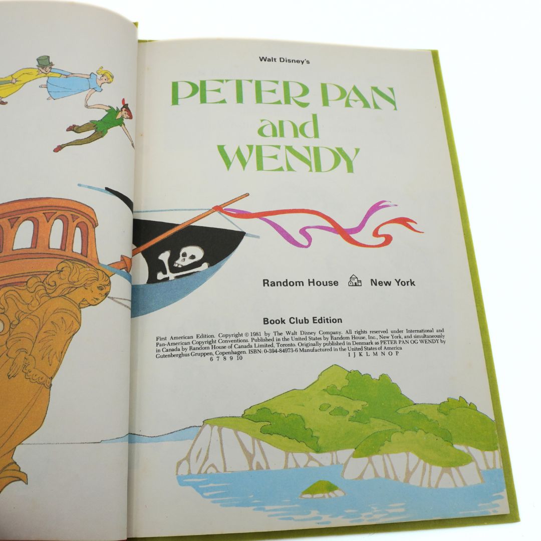 Open book cover of 'Peter Pan and Wendy' with illustrations and title text.