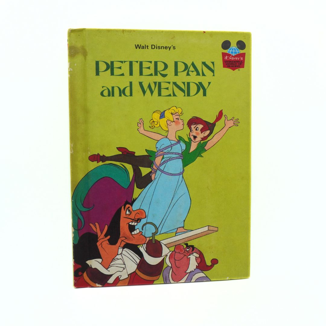 Vintage book cover of 'Peter Pan and Wendy' by Walt Disney with characters on a green background.