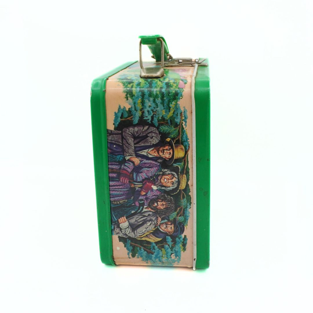 Vintage lunchbox with illustration of people in a forest on a white background