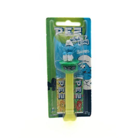 Front on photo of a Pez Dispenser Smurf with a green and yellow colour palette, unopened in packaging