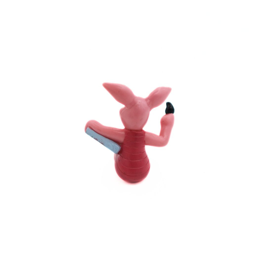 Back of a Winnie the Pooh Piglet figurine with a grey canvas and black brush