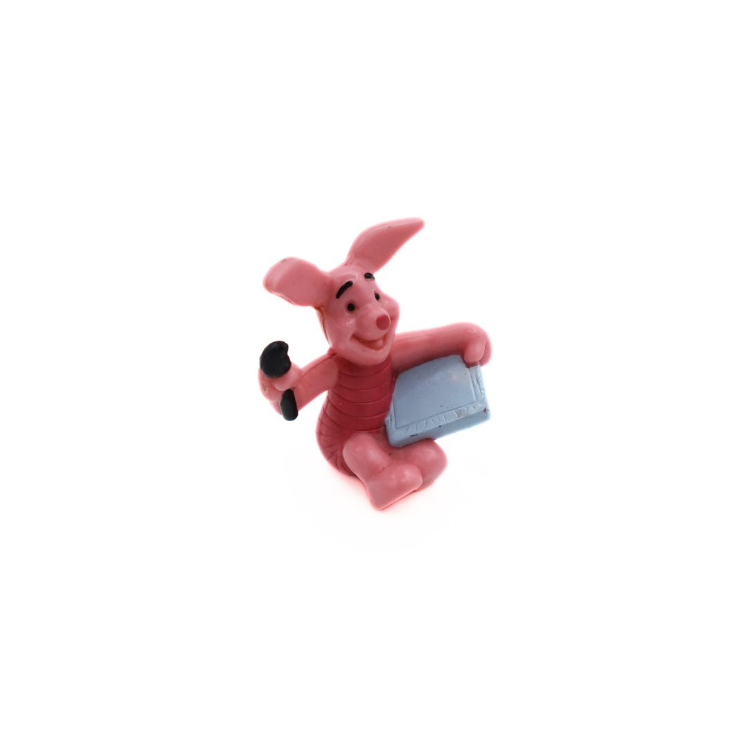 Pink Winnie the Pooh Piglet figurine with a grey canvas and black brush