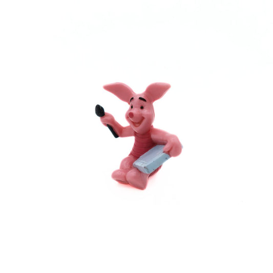 Pink Winnie the Pooh Piglet figurine with a grey canvas and black brush