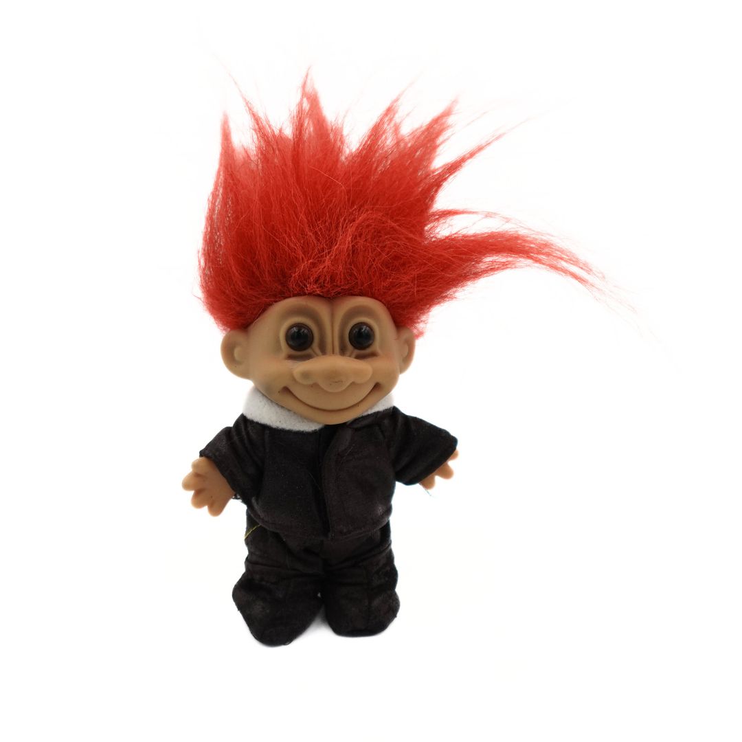 A photo of the 90s Russ Troll Doll Pilot in a dark brown outfit with orange hair