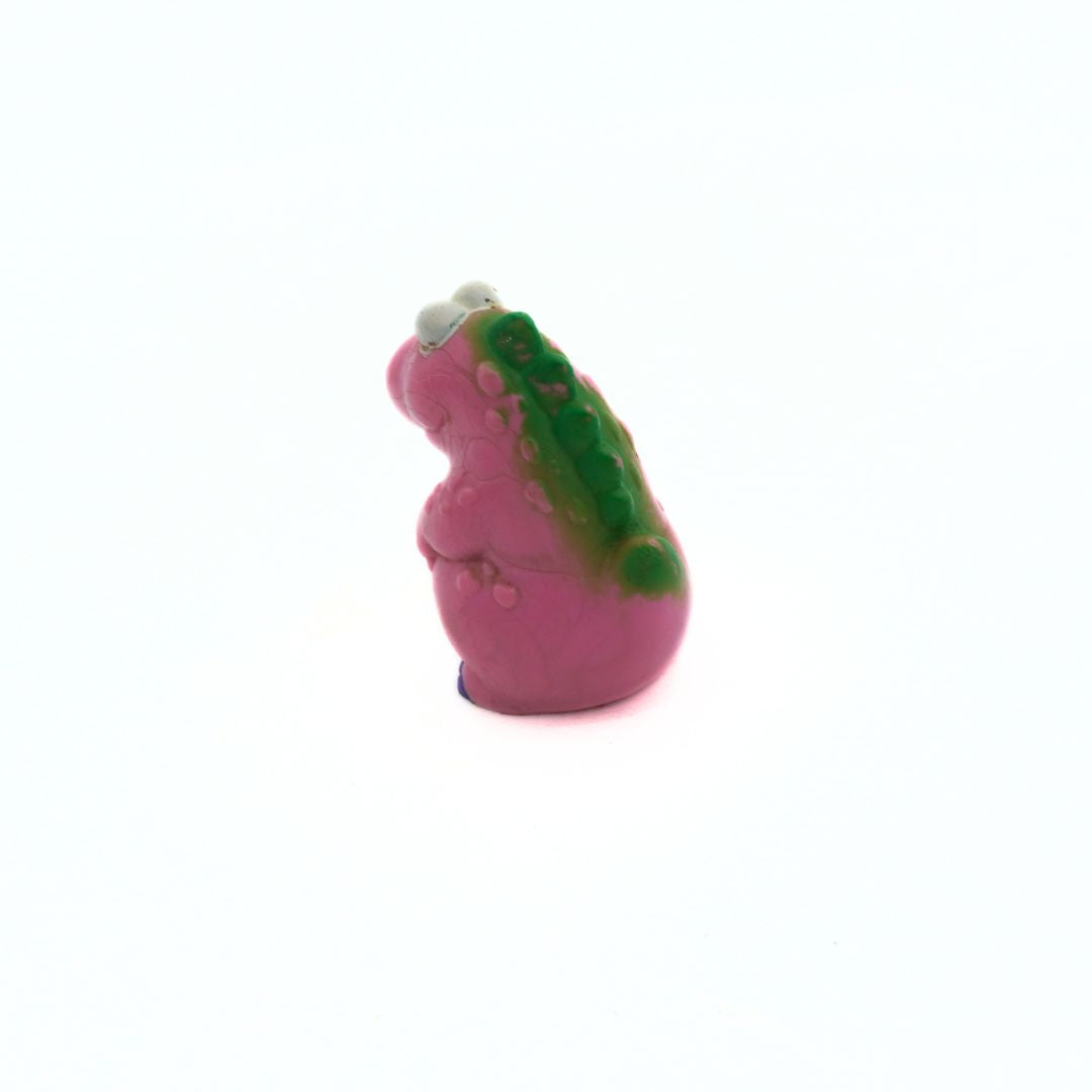 Small pink and green toy figure on a white background