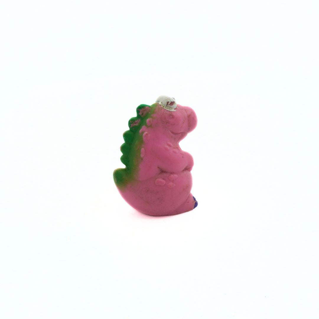 Pink dinosaur toy with green spikes on a white background