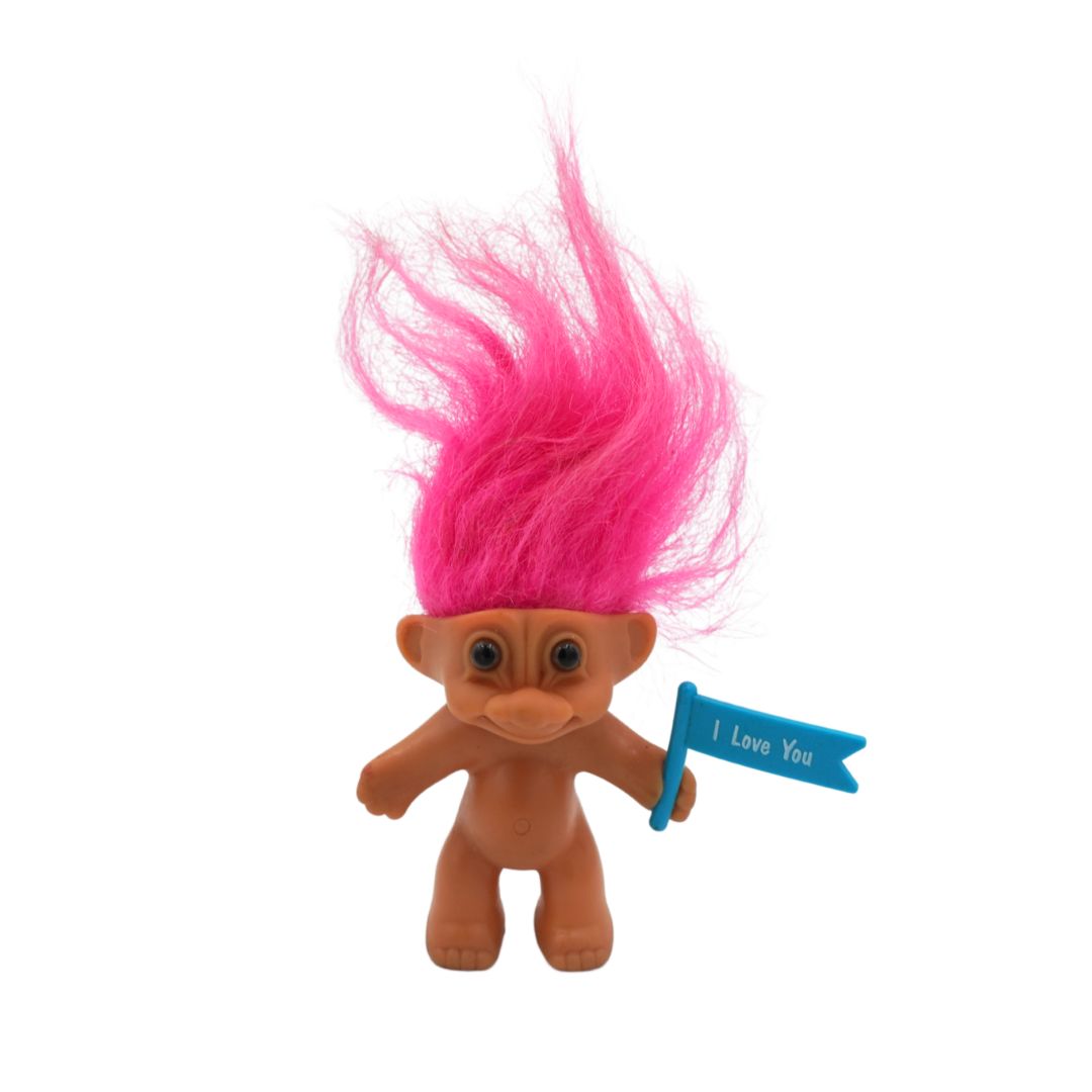Toy figure with pink hair and a blue flag saying 'I Love You' on a white background