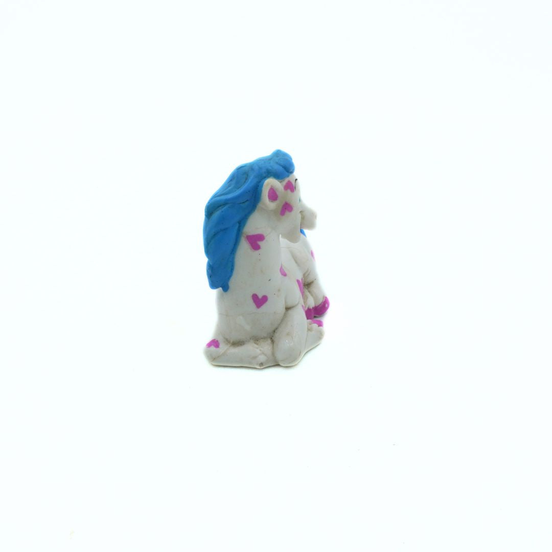 Blue and white figurine with pink hearts on a white background