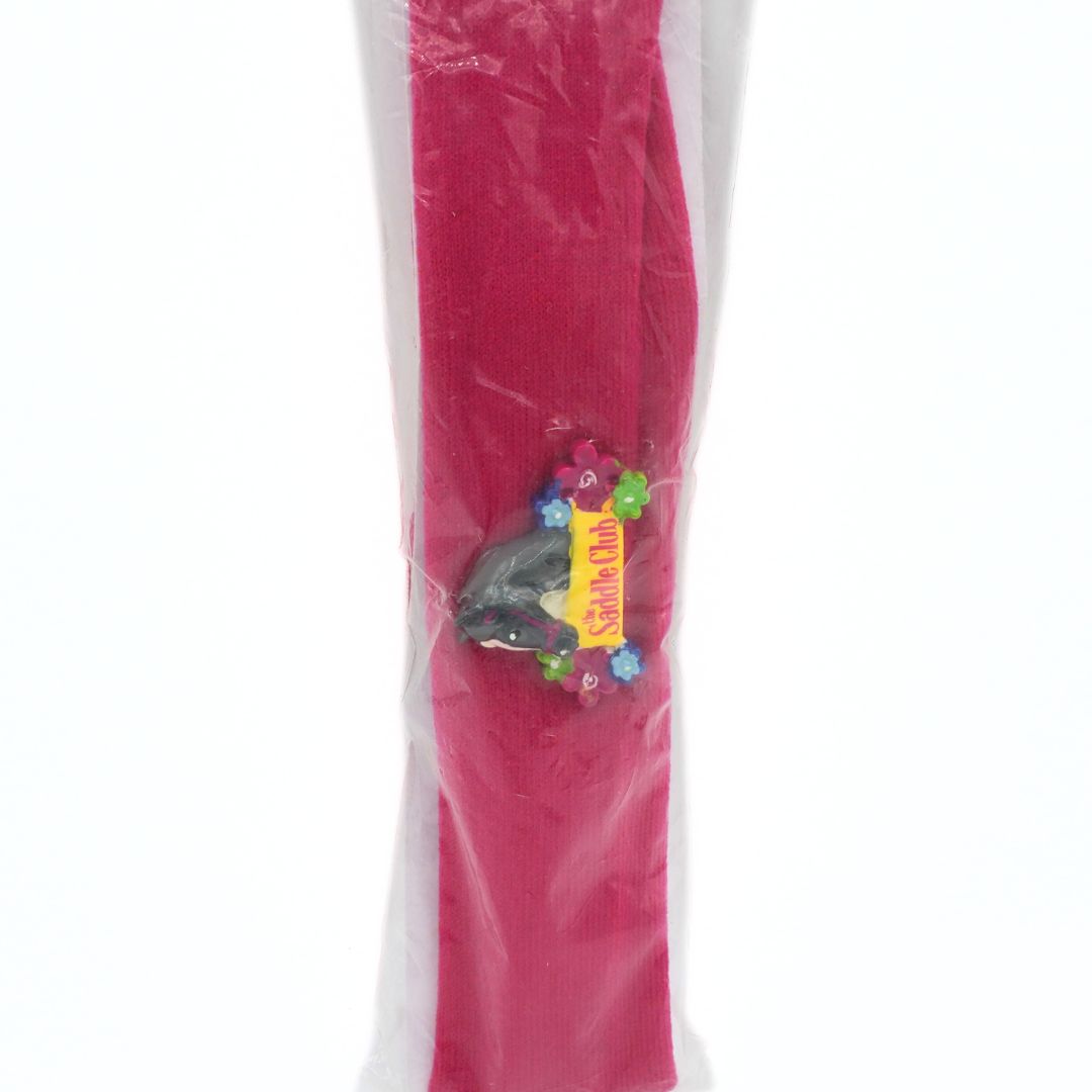 Pink headband with a colorful logo tag on a white background