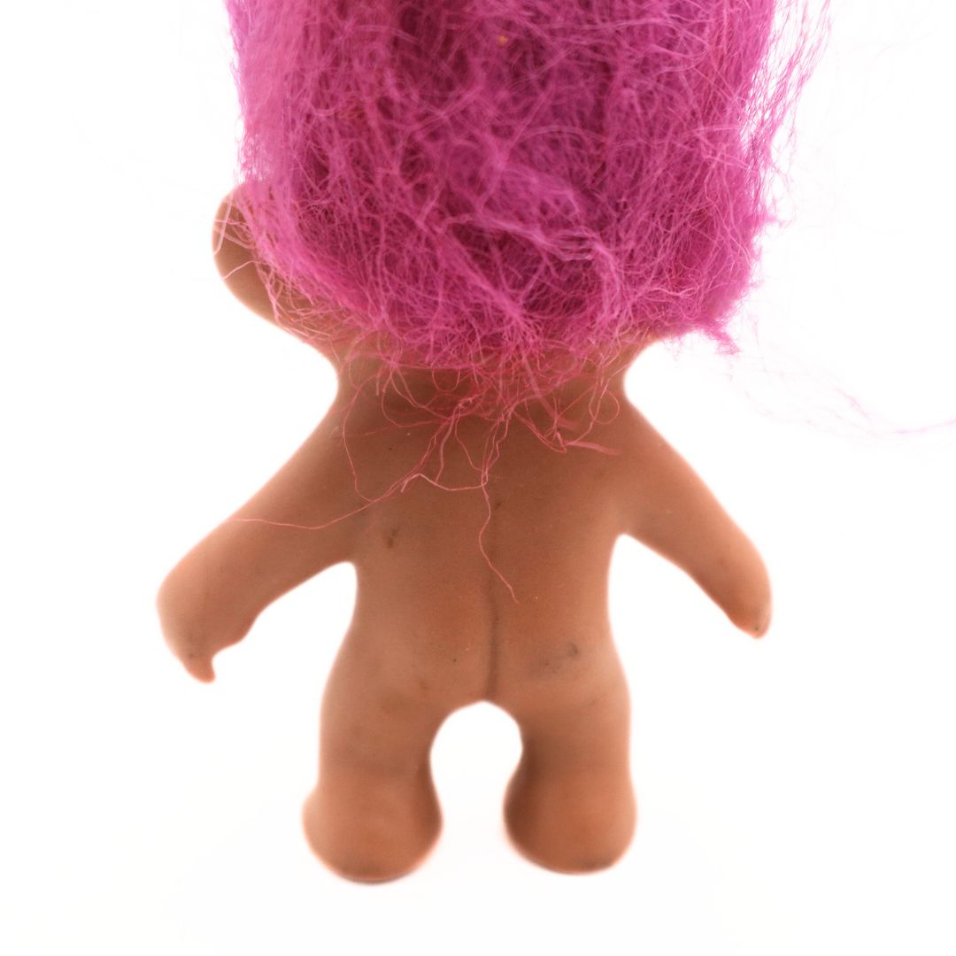 Closeup of marks on a vintage 90s pink haired Troll Doll