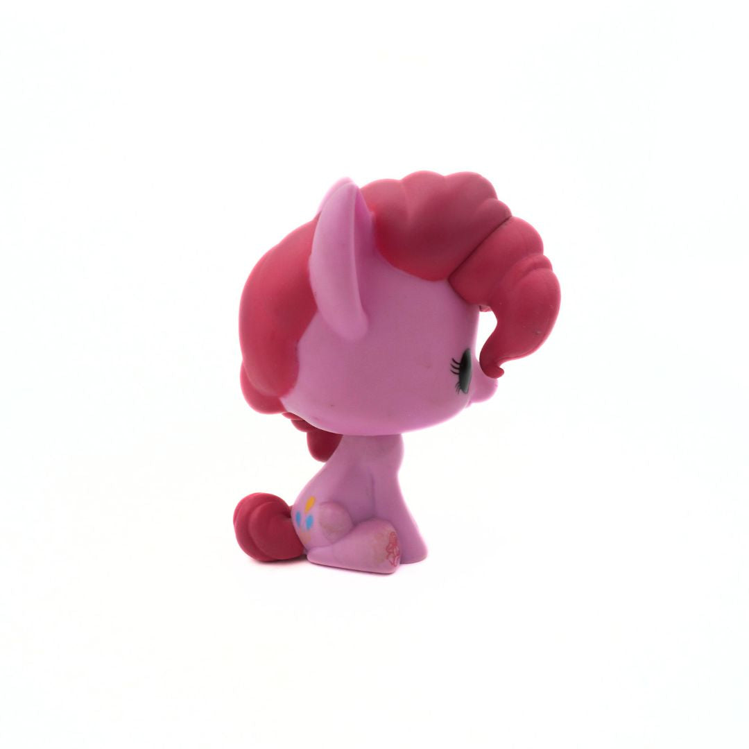 Pink toy figure with red hair on a white background