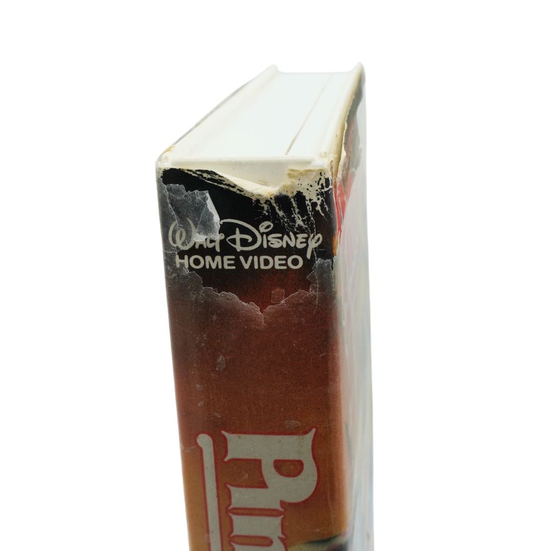 A close-up side view of a vintage Walt Disney Home Video VHS case, showing the worn plastic shrink wrap and the spine with the title 'Pinocchio' partially visible.