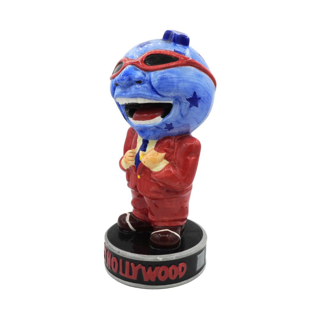 Ceramic figure with blue face and red outfit on a white background