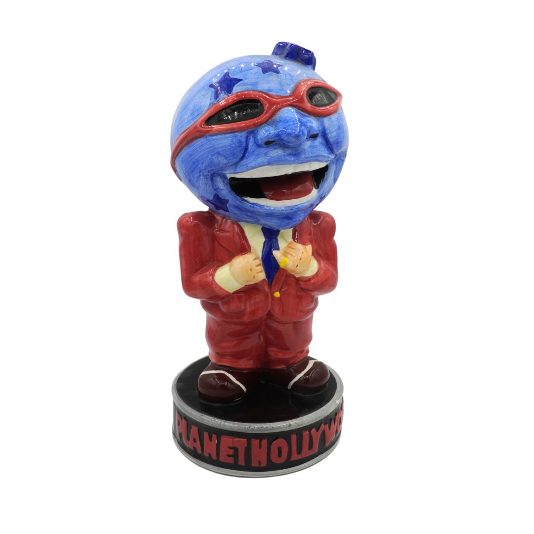Ceramic figure with blue face and red outfit on a white background