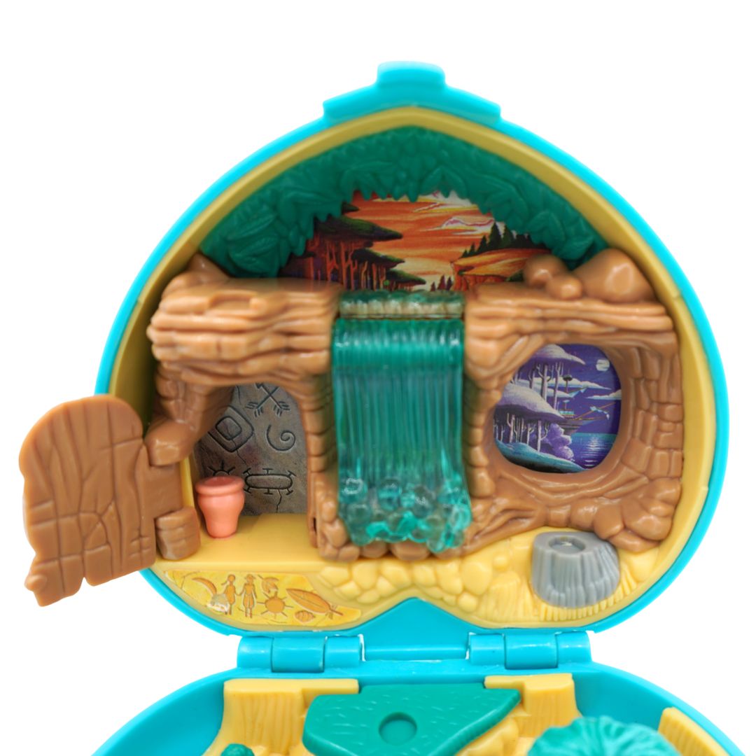 Interior of a 1995 Bluebird Polly Pocket Pocahontas playset showing a sunset, forest scene and waterfall.