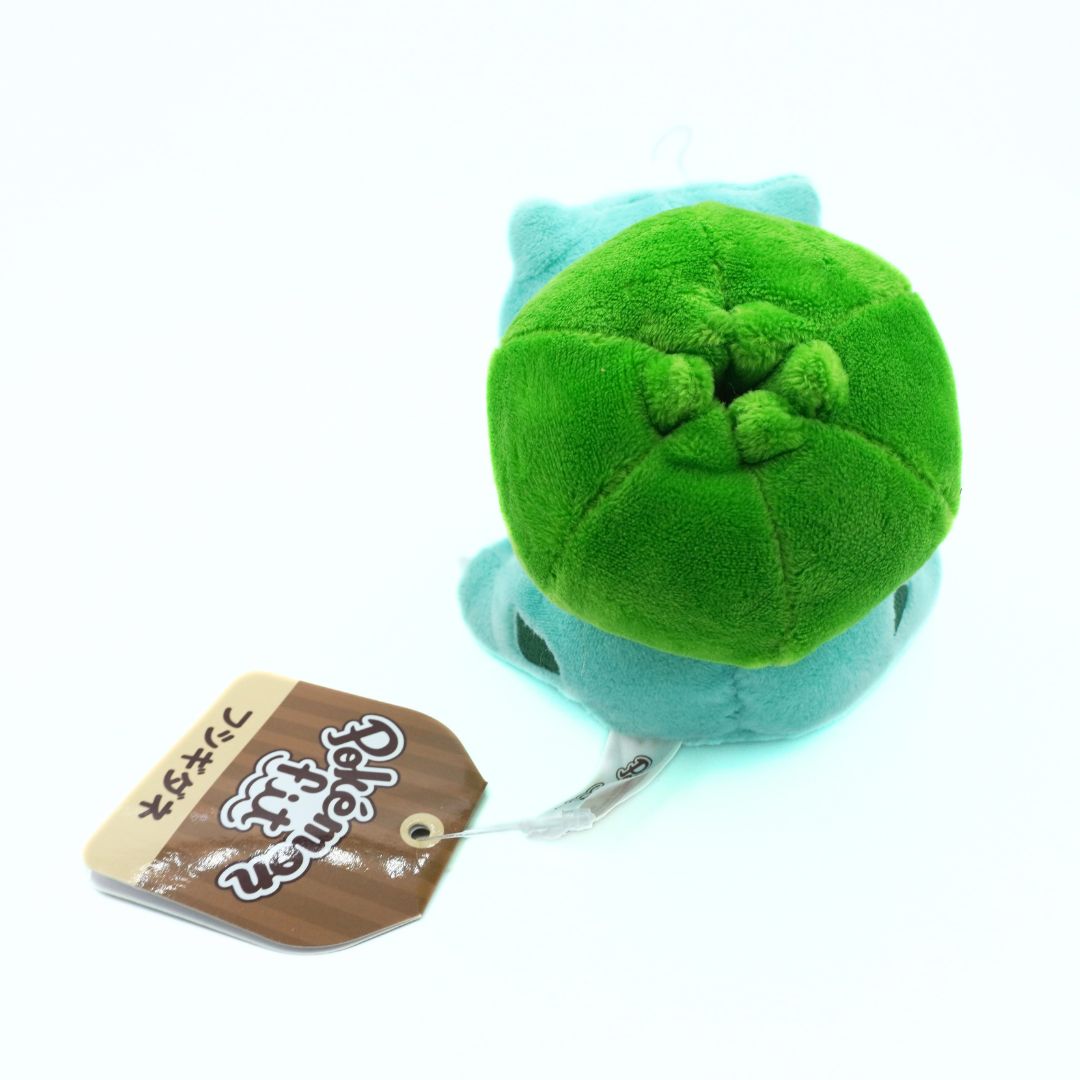 Plush toy with a green top and blue bottom, featuring a tag on a white background