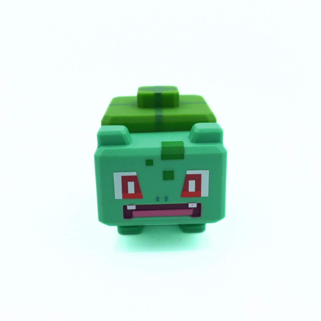 Green toy figure with a blocky design on a white background