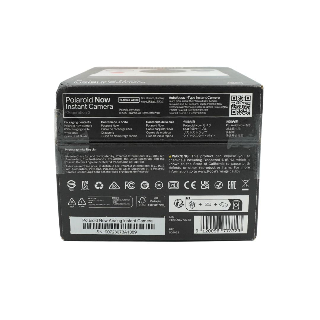 A black and white polaroid camera in a black box, titled the Polaroid Now