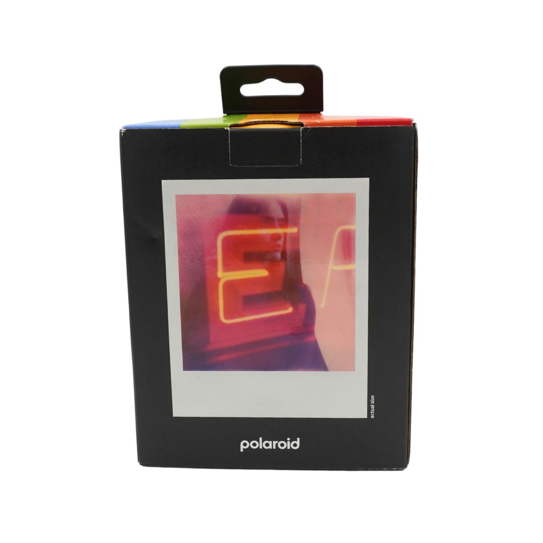 A black and white polaroid camera in a black box, titled the Polaroid Now