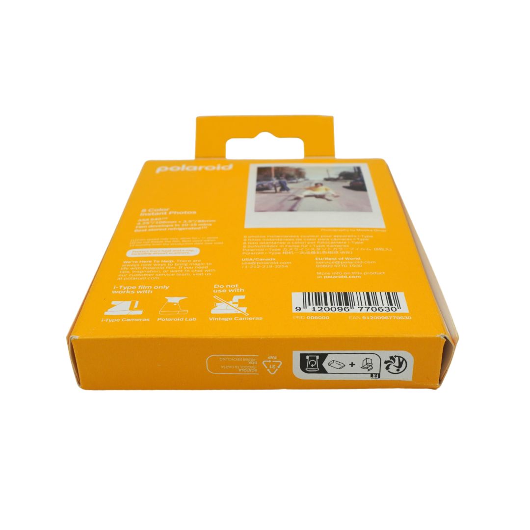 The back of a Polaroid instant camera film box in bright orange, showing product information, a barcode, and a sample photo print on a white background.