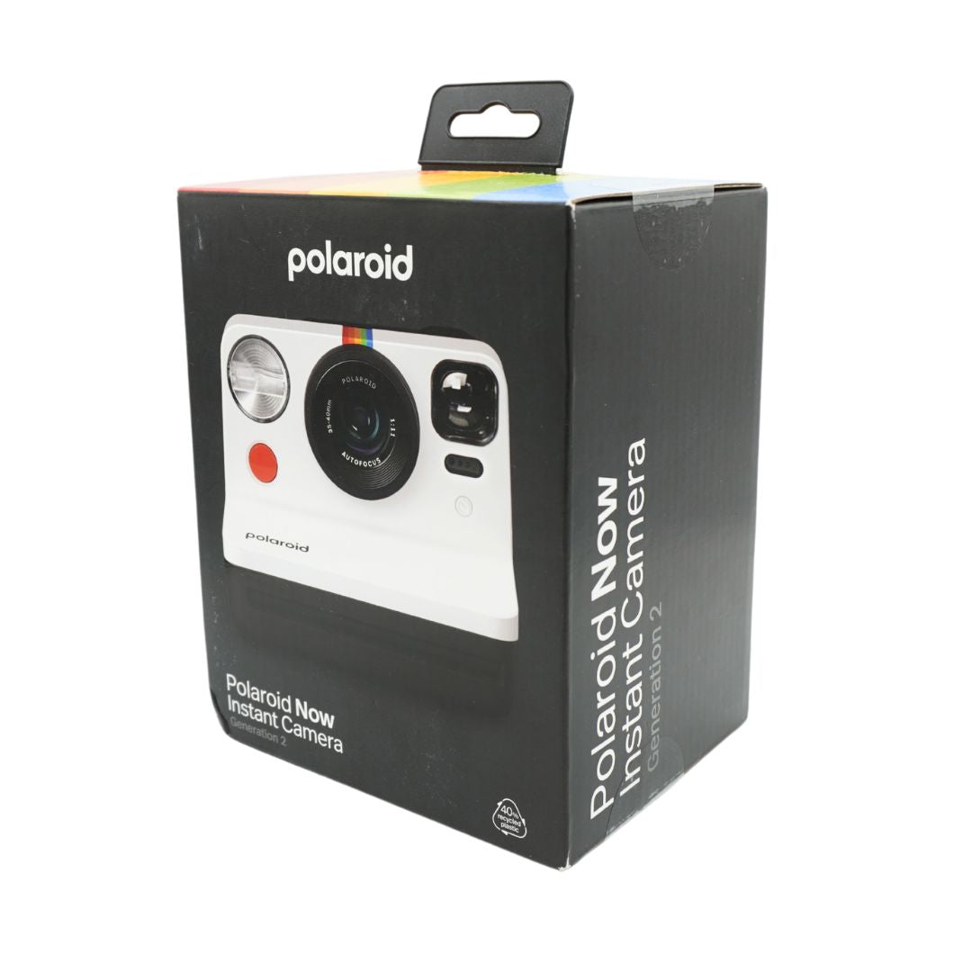 A black and white polaroid camera in a black box, titled the Polaroid Now
